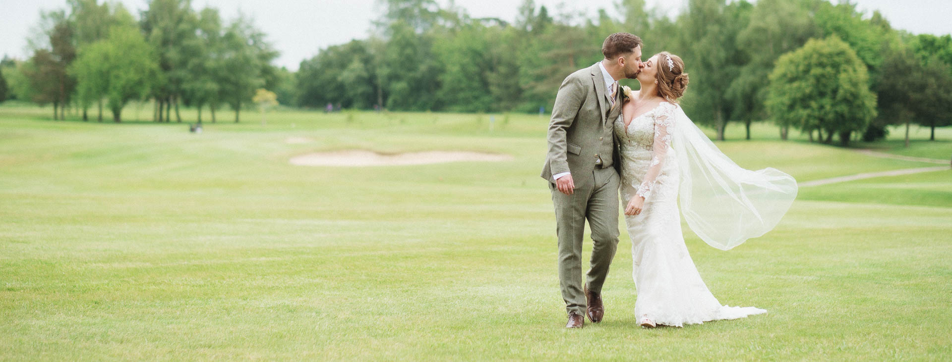 Bride and Groom having a kiss whilst walking across the golf course, Hintlesham Golf Club, Heffs Photography, Weddings, Suffolk Wedding,