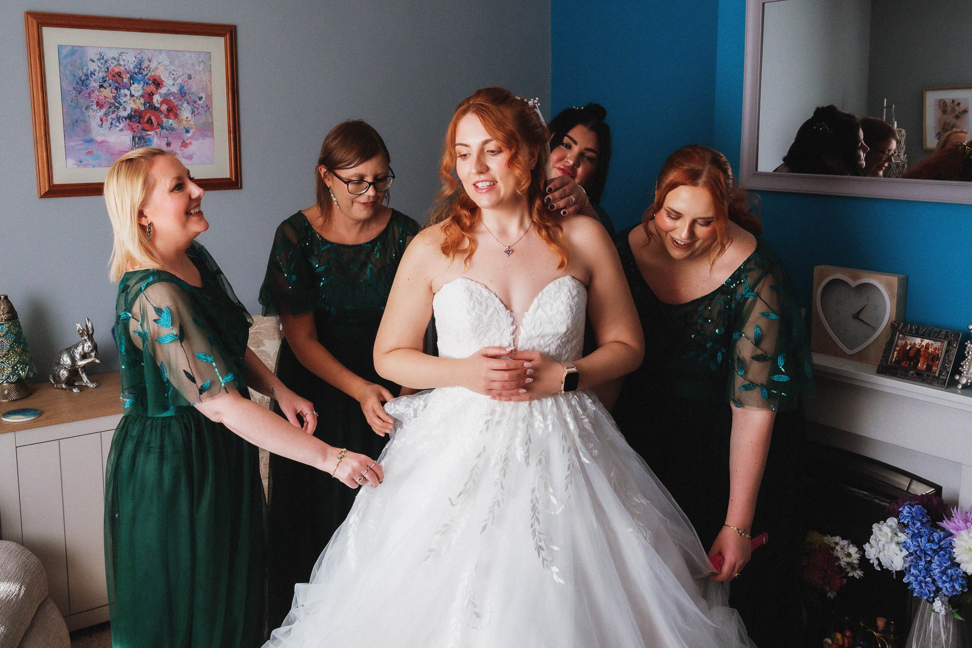 Lorna with her bridesmaids in green dresses sharing a laugh before the wedding