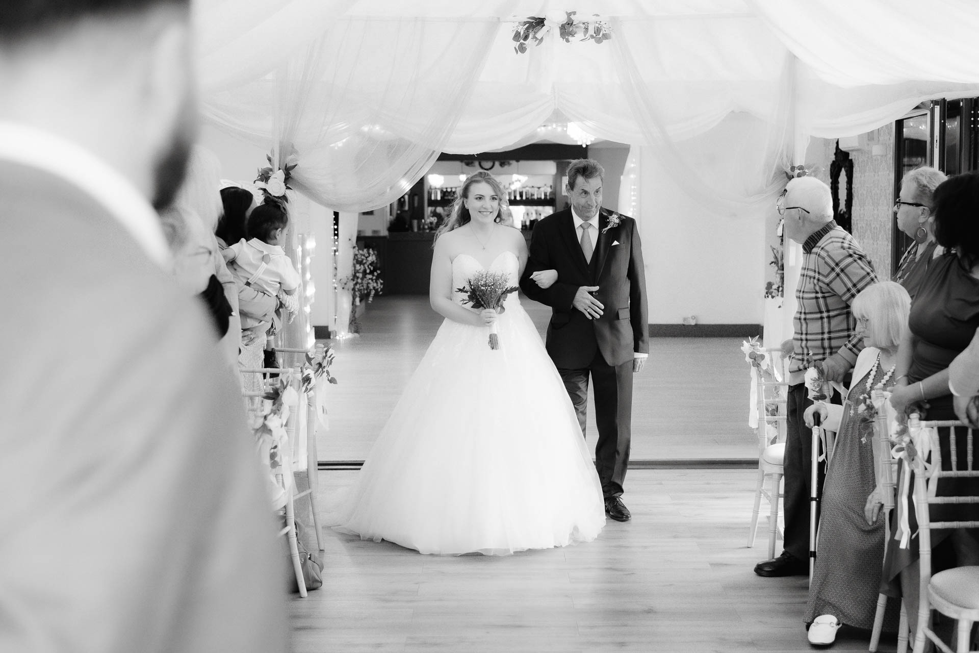 Lorna walking down the aisle at Venue 16, escorted by her father