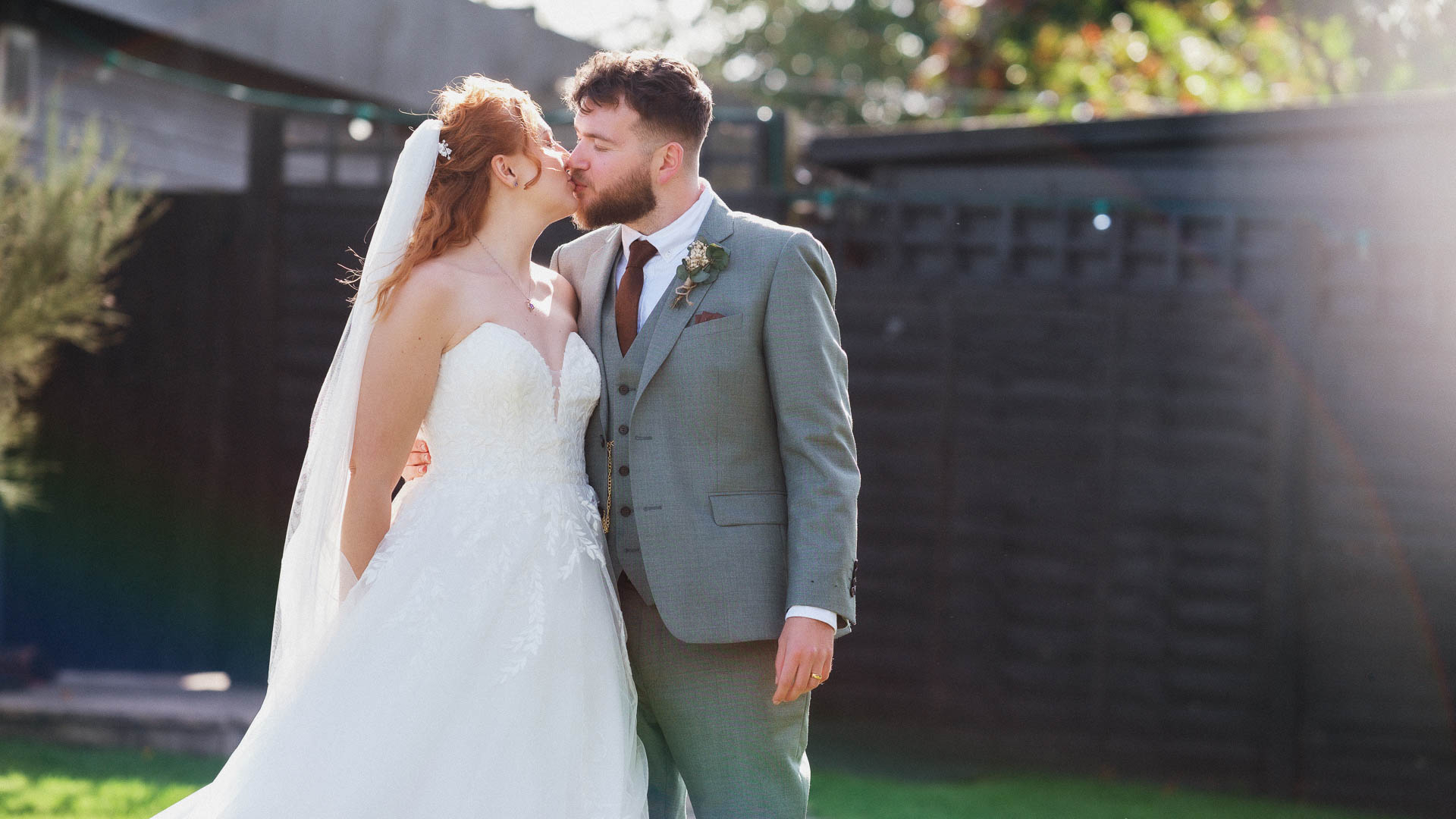 couple kissing with sun shining behind